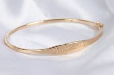 Once we perfected the sample for this bracelet we didn't take her off for 2 years. Fancy, but not too fancy. Just the right shape. Just the right width. The one thing you'll always wear, with your personalized hand engraving. Solid 14k yellow, rose or white gold bracelet with your name, text or bespoke design Engravable on front and inside Hand engraved to order The Signet Bracelet Sizing Small: 6.3in circumference; 52.10mm x 50.25mm diameter Medium: 6.8in circumference; 56.00mm x 54.00mm diamet Adjustable Engraved Bangle For Formal Occasions, Elegant Engraved Cuff Bracelet For Formal Occasions, Elegant Engraved Cuff Bracelet For Formal, Signature Engraved Bracelet Jewelry, 14k Stamped Gold Bracelet For Wedding, Signature 14k Gold Wedding Jewelry, Elegant Adjustable Engraved Bangle, Elegant Adjustable 14k Stamped Bracelets, Elegant Engraved Adjustable Bangle