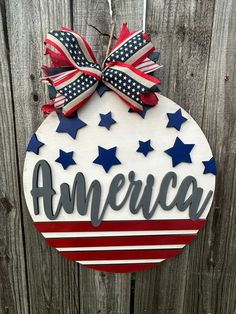 an american sign hanging on the side of a wooden fence with red, white and blue stars