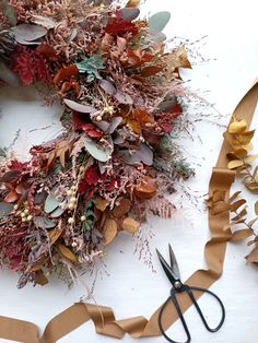 a wreath made out of brown paper with scissors next to it