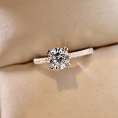 a diamond ring sitting on top of a pillow