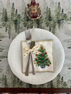 a white plate topped with a christmas tree on top of a table next to a fork and knife