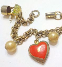 "Vintage Coro charm bracelet. 7\" long with signed flip fastener. Charms included are two wishing wells with a working winder, a lantern, a double heart with pink enamel (chipped enamel), and three faux pearls. Classic vintage Coro. Very good vintage condition." Vintage Nickel-free Heart Bracelet As Gift, Vintage Nickel-free Heart Bracelet Gift, Vintage Charm Bracelet With Heart Charm, Nickel-free Vintage Heart Bracelet As Gift, Vintage Heart Charm Bracelet As A Gift, Vintage Heart Charm Bracelet For Gift, Vintage Heart Charm Bracelet With Lobster Clasp, Vintage Metal Charm Bracelet For Valentine's Day, Vintage Heart-shaped Charm Bracelet For Valentine's Day