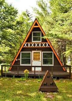 a - frame cabin in the woods surrounded by trees