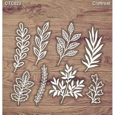 paper cutouts with leaves and branches on wooden background, for crafting or scrapping