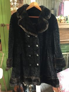 This is a really neat coat all made of faux fur by Sterling of Winnipeg. The body of the coat is made of what looks like simulated black Persian lamb, accented by glossy brown faux fur collar, cuffs and bottom trim. The coat is double breasted and has all original buttons. It has two outer pockets and belt detail in back and is fully lined. In excellent condition. Fits like a women's size medium, on the larger side. The actual measurements, taken with the coat lying flat, are: shoulder to shoulder, 17 inches; armpit to armpit, 22 inches; sleeves, 23 inches; total length, 38 inches; bottom edge, 28 inches. Black Fur Coat With Faux Fur Trim, Black Faux Fur Coat With Faux Fur Trim, Vintage Faux Fur Trim Coat For Fall, Long Fur Coat With Faux Fur Trim For Fall, Fall Long Fur Coat With Faux Fur Trim, Elegant Brown Fur Coat For Cold Weather, Vintage Faux Fur Lined Outerwear, Vintage Faux Fur Coat For Cold Weather, Elegant Brown Faux Fur Outerwear