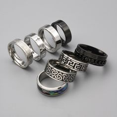 Choose from 8 of our high-quality stainless steel silver men's rings. Including: 1. Saint Cross ring 2. Celtic Knot Ring 3. Aztec Numeral Ring 4. Roman Band Ring  5. Black Classic Band Ring 6. Classic Band Ring 7.Abalone Shell Ring  8. Black Chain Ring ➤Weighty and Durable Stainless Steel ➤The perfect, versatile ring for daily wear ➤Multiple Sizes available ➤Made with High-Quality 316L Stainless Steel for a premium finish Please Note: This includes 1 ring not a full set of 8. Please pick the style that you would like from the photos. Please check our size chart in the last image before ordering. Shipping: We aim to ship your order out as soon as possible and offer Free First Class Delivery to the UK. We also offer worldwide shipping which we send with international standard delivery. Any q Cool Rings For Men Silver, Black Stainless Steel Couple Rings For Promise, Durable Silver Promise Ring, Durable Silver Metal Ring, Thick Silver Rings, Rings For Men Silver, Thick Silver Ring, Silver Rings For Men, Chrome Hearts Ring