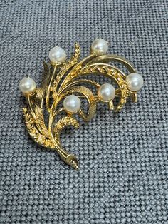 Vintage Faux White Pearl & Brushed Gold Brooch Signed Lisner, c. 1950s Beautiful mix of brushed gold-tone metal and faux pearls in a leaf form.  Signed Lisner and is in good condition with no turning of the metal.  This is a classic example of their timeless design from the 50s. Measurements Brooch: ~2" x 1 1/2" See other jewelry for more amazing deals! A Brief History of Lisner Vintage Jewelry Unlike some of Lisner's competitors, the jewelry the company produced in the 1950's and 1960's looks a 1950s Jewelry Style, 1960s Looks, 1950s Jewelry, Trifari Jewelry, Gold Brooch, Jewelry Style, Gold Brooches, The 50s, White Pearl