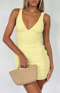 Summer dresses don't get cuter than this... The Got Her Own Mini Dress Lemon is a mini dress made for sunny summer days. Features a plunge neckline, crinkle fabric, lined fabric, mini length, thick straps, slip-on style and lined fabric. Pair with a thong heel and a mini bag for a chic look! - 65% Polyester 30% Cotton White Mini Dress Classy, Tequila Sunrise Dress Theme, Cute Unique Hoco Dresses, Pale Yellow Hoco Dress, Casual Hoco Dresses, Yellow Dress With Flowers, Yellow Hoco Dress, Floral Hoco Dress, Yellow Spring Dress