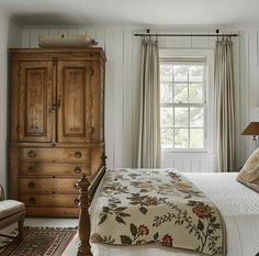 a bedroom with white walls and wooden furniture