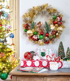 a christmas wreath is hanging on the wall next to presents and other holiday decor items