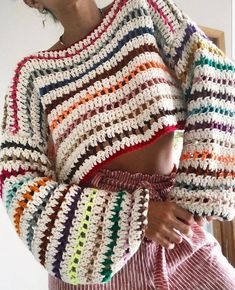 a woman wearing a colorful crochet sweater