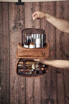 a person holding a brown bag filled with cosmetics