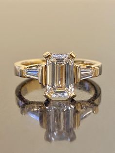 an emerald cut diamond ring with three baguets