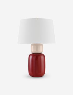 a red table lamp with a white shade on the top and one light on the bottom