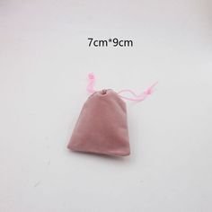 a small pink pouch is shown on a white surface with measurements for the size and length