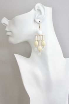 18k gold plated brass earrings with white agate, magnesite, acrylic, and glass. Each earring weighs .445oz and measures 3.625in from top of hook. Modern White Dangle Linear Earrings, Geometric Chandelier, White Agate, Multi Strand Necklace, Gift Card Sale, Brass Earrings, Multi Strand, Light Yellow, Chandelier Earrings