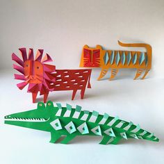 three paper animals made to look like alligators and crocodiles, each with different colors