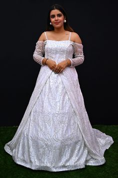 Its a stunning floor-length outfit made from Net fabric in an elegant White color. It features a Off -Shoulder Neck at the front and a Deep Neck at the back. The gown is designed with Cold Shoulder sleeves style. It is embellished with intricate work including Cutdana, Sequins, and Stone work, making it a beautiful choice for special occasions and events. Complete the look by wearing Stone jewelry and bracelet. There might be little color variations in the image and original product due to photo Floor-length Wedding Dress With Sweep Train For Debutante Ball, Floor-length Sweep Train Wedding Dress For Debutante Ball, Intricately Embroidered Floor-length Wedding Dress For Reception, Intricate Embroidered Floor-length Wedding Dress For Reception, Intricate Embroidery Floor-length Wedding Dress For Reception, Floor-length Wedding Dress With Intricate Embroidery For Reception, Embellished Floor-length Gown For Reception, Embroidered Floor-length Ball Gown For Party, Embroidered Floor-length Wedding Dress For Reception