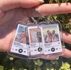 someone holding two mp3 player key chains in their left hand and another one with the same image on it