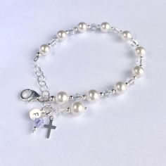 This lovely First Communion bracelet and earrings set is sure to be the perfect gift! The beautiful bracelet doubles as a single decade rosary. This classic bracelet has been a big seller as First Communion jewelry, Confirmation jewelry, Easter bracelet, Flower Girl gift, Maid-of-Honor jewelry, Bridesmaids matching bracelets, Mother-of-the-Bride jewelry, Godmother gift, and as Bridal jewelry. Description: -Bracelet measures 5 ½ inches plus a 1-inch extension chain -fits First Communion age (2nd Round Beads Jewelry For Mother's Day Jewelry Making, Mother's Day Jewelry Making With Round Beads, Elegant Adjustable Rosary Bracelet For Birthday, Adjustable Nickel-free Pearl Bracelet For Gift, Round Pearl Crystal Bracelet For Gift, Sterling Silver Rosary Bracelet Gift, Classic White Charm Bracelet As Gift, Sterling Silver Rosary Bracelet With Round Beads As Gift, Sterling Silver Rosary Bracelet With Round Beads