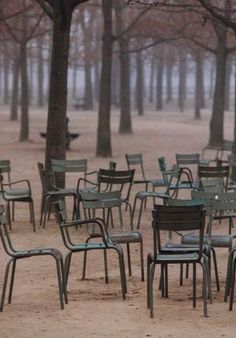 there are many chairs and tables in the park with no one sitting on them or standing around