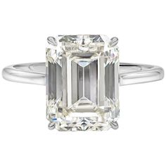 an emerald - cut diamond ring set in 18k white gold