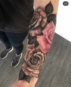 a person with a tattoo on their arm and some roses in the middle of it