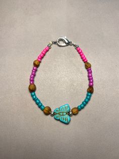 Introducing our Navajo-inspired beaded bracelet, a vibrant celebration of tradition and craftsmanship. Handcrafted with care, this stunning piece features a captivating blend of pink, purple, and blue beads, accented with juniper beads for a unique touch. Adorning the center is a small faux turquoise butterfly, adding a touch of Southwest charm. Measuring between 16.5cm to 17cm  in length, this bracelet exudes elegance and grace, perfect for everyday wear or as a meaningful gift honoring Native Hippie Style Colorful Round Bead Jewelry, Spiritual Pink Beaded Bracelets For Beach, Spiritual Pink Friendship Bracelets With Round Beads, Bohemian Turquoise Bracelets With Spacer Beads, Bohemian Turquoise Beaded Bracelets With Spacer Beads, Artisan Turquoise Beaded Bracelets For Festival, Turquoise Hippie Beaded Bracelets For Jewelry Making, Artisan Beaded Bracelets With Colorful Beads For Festivals, Artisan Beaded Bracelet With Colorful Beads For Festivals