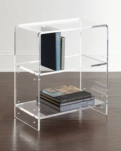 a stack of books sitting on top of a wooden floor next to a white wall