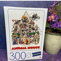 an animal house jigsaw puzzle next to a potted plant and purple flowers