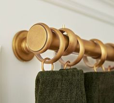 an image of a towel rack with rings on the top and green towels hanging from it's hooks