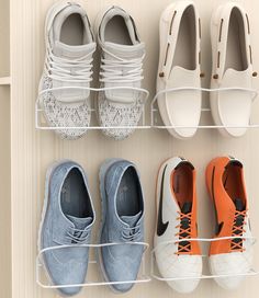 four pairs of shoes are hanging on the wall next to each other in a shoe rack