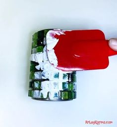 a hand holding a toothpaste that is on top of an ice cube tray