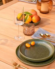 a table with plates, silverware and oranges on it is set for two