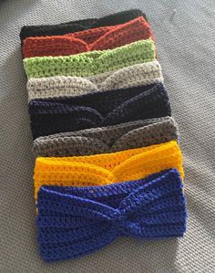 there are four crocheted headbands on the bed