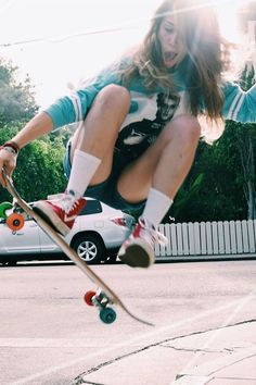 a girl is jumping in the air on her skateboard while doing a trick outside