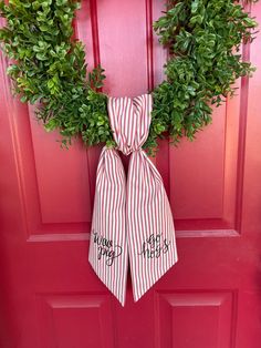 a red door with a wreath on it and two ties tied to the front door