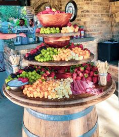 a table topped with three tiered trays filled with fruits and veggies