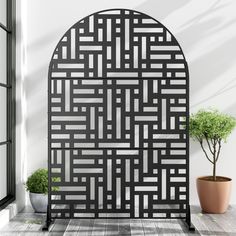 a black and white design on a wall next to a potted plant