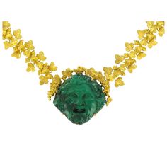 Necklace in 18K matt yellow gold necklace, eagle head hallmark. Consisting of golden vine leaves and bunches of grapes hinged together, the centrepiece of this unusual necklace is a malachite cameo of a grinning ‘Bacchus’. The clasp is a rectangular ratchet of matt gold. The cameo dates from the 19th Century, the supporting golden necklace was created by our workshop. Length: 45 cm, mesh: 1.5cm - Cameo: Length: 3.2 cm, width: 3 cm. Our opinion: This piece of jewellery was imagined and created in the Empire style, entirely by hand. The finely worked leaves and bunches of grapes beautifully enhance the wonderfully expressive malachite cameo. Specialized in antique and creation jewelry since 1975, we deliver all our jewel with their certificate of authenticity, written by our certified antiqu Unusual Necklace, Malachite Jewelry, Vine Leaves, Golden Necklace, French Empire, Grape Bunch, Yellow Gold Necklace, Eagle Head, Empire Style