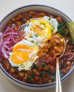 a bowl filled with beans, onions and eggs