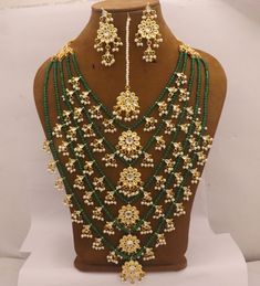 Kundan 5 Layers Long Rani Haar Necklace Earrings Tika Jewelry Set, Green Beads Minakari Work Pearls Jewelry, Bridal Rani Haar Wedding Set Metal = Gold Plated Occasion = Wedding ,Party Wear, Bridal Color = Green and Yellow Size = Necklace Length = 35 CM Earrings/Studs = 7 CM Tika = 10 CM Please update shipping profile for Express shipping (delivery in 3 to 7 working days) 100% Satisfaction Guarantee: 1 Year Warranty, Long Lasting Plating, High-Quality Stones Occasion: Perfect choice for any India Temple Jewelry Sets With Dangling Beads For Wedding, Wedding Jewelry Sets With Dangling Beads For Festivals, Chandbali Kundan Necklace With Dangling Beads For Wedding, Temple Jewelry Beaded Necklace For Wedding With Dangling Beads, Traditional Beaded Necklaces With Dangling Beads For Weddings, Green Temple Jewelry Beads For Wedding, Gold Bridal Necklace With Dangling Beads For Wedding, Traditional Wedding Beaded Necklaces With Dangling Beads, Traditional Wedding Necklace With Dangling Beads