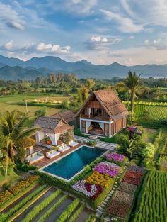 an aerial view of a house with a pool surrounded by greenery and mountains in the background