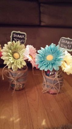 three vases filled with flowers on top of a wooden table