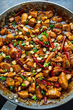 a pan filled with chicken, peppers and cashews