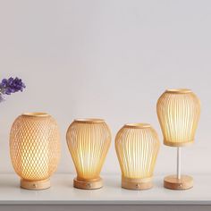 three vases and one lamp on a table