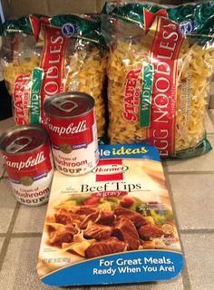 three packages of food sitting on top of a counter next to cans of noodles and soup