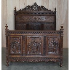 an old wooden bed with carvings on it