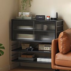 a brown leather chair sitting in front of a book shelf with books on top of it