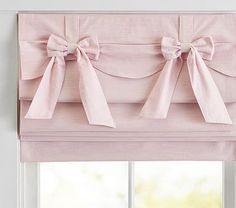 pink bow tie roman blind with matching valance and sashes in front of window